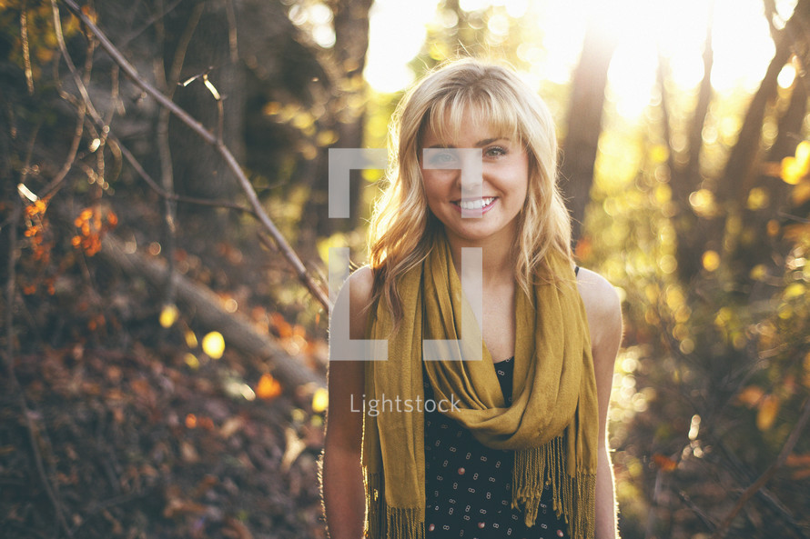 woman standing in a forest smiling 