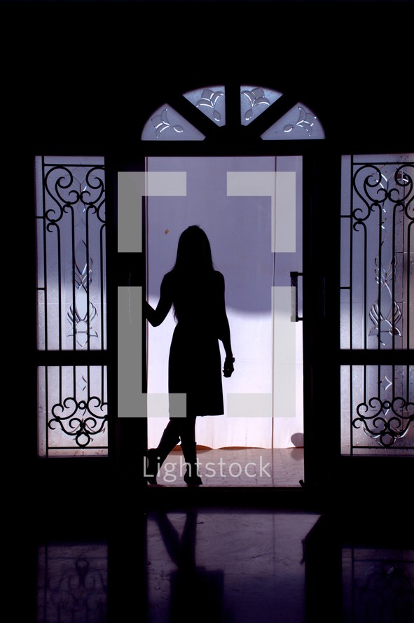 silhouette of a woman standing in a doorway 
