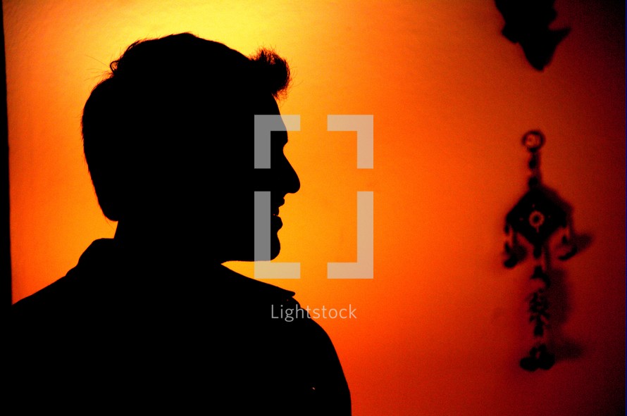silhouette of a man with glowing orange and yellow background 