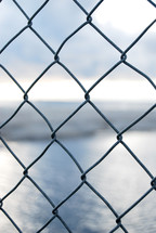 view of water through a chain link fence 
