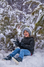 Boy laughing while playing in the snow