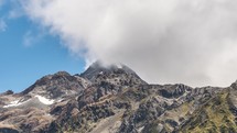 White clouds over rocky alps mountain peak in New Zealand wilderness landscape Time-lapse
