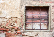 Old window with iron gratings of a house in Tuscany.