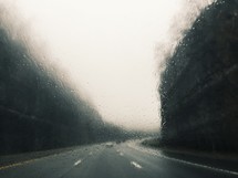 wet car window and highway ahead 