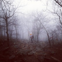 rocky fog covered hillside with a hiker