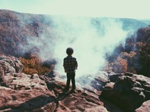 a young boy watching the fog 