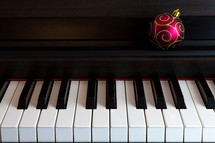 a Christmas ornament on a piano 