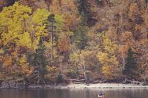 a kayaker stops paddling to stare at the autumn colours 
