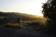 sunrise over a bench looking out at a mountain view