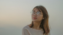 face of a young woman in glasses 