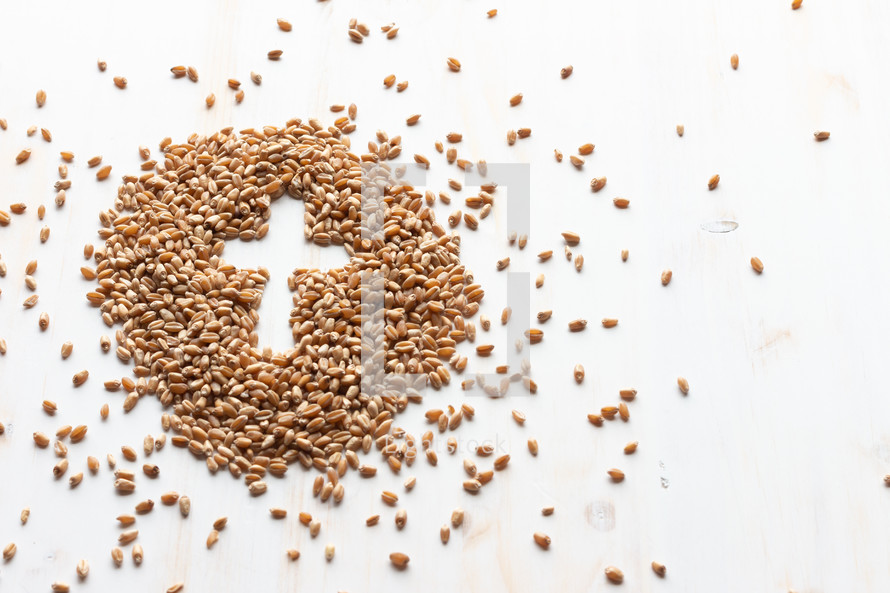 pile of wheat grains on white with cross shape 