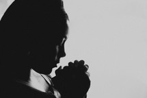 Silhouette of a praying woman.