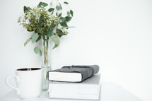 Bible, coffee cup, and flowers in a vase 