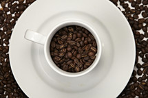 Coffee beans inside a white mug 