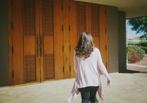 A woman walking towards the doors of a Catholic church