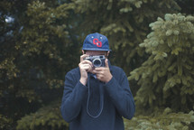 man taking a picture with a camera outdoors 