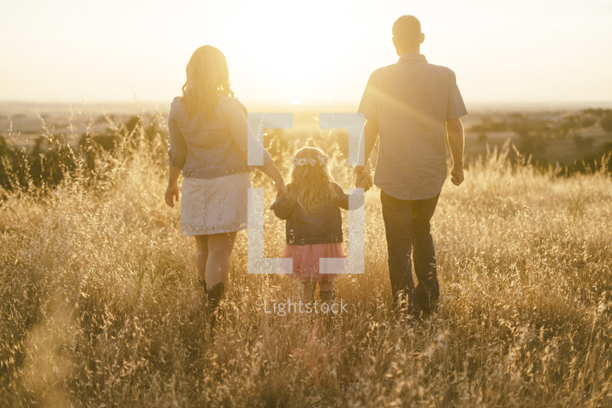 a family standing in a field of tall grasses 