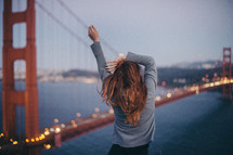 a woman stretching in front of the golden gate bridge 