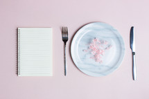 Diet connect wit notebook, marble plate, knife and fork over the pink background. 