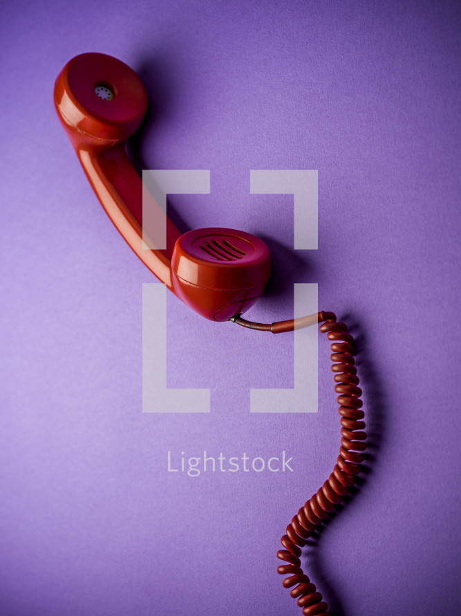 red rotary phone on purple background 