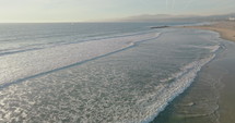 Aerial view of drone flying above beautiful beach with views of ocean waves