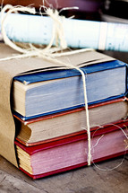  Books wrapped in brown paper and tied with twine.