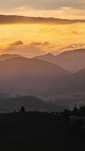 Vertical panorama of golden clouds sunset sky over autumn mountains timelapse outdoor background
