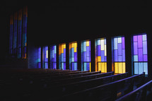 stained glass windows in a church and pews