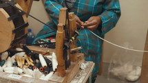 Woman handle spinning thread on a spindle 