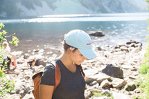 a woman hiking along a rocky shore 