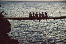 bridal party sitting on a pier