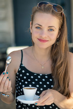 a young woman drinking espresso in a city 