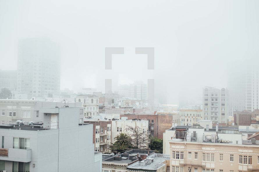 City buildings covered in fog.