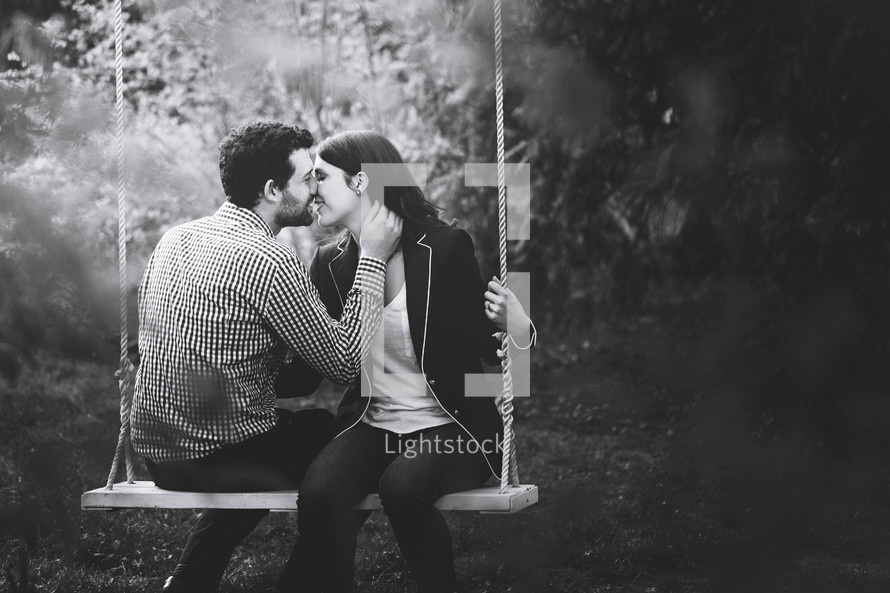 a couple on a swing kissing 