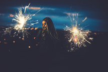 a woman holding sparklers 