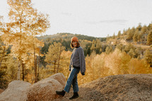 a woman standing on a mountaintop in fall 