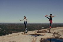 women balancing on pipes on a mountaintop