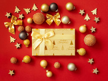 gold Christmas ornaments on red with a gift 