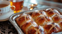 Easter. Good Friday. Hot cross buns on a metal tray with a cup of tea