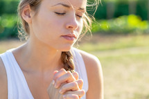 a woman praying outdoors 