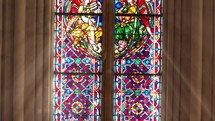 Stained glass with celestial blue and religious scenes 
