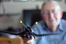 elderly man holding a model airplane 