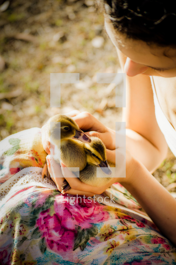 a woman holding ducklings 