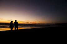 silhouette of a couple walking holding hands on the beach love relationship marriage