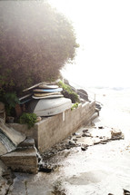 overturned boats and surfboards along a shore 