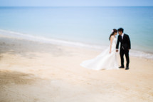 a bride and groom on a beach 