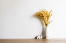 vase of tall grasses and tiny houses 