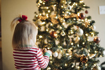 toddler girl in front of a Christmas tree 