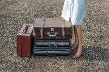 legs of a woman standing next to luggage 
