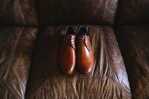 dress shoes on a leather couch 